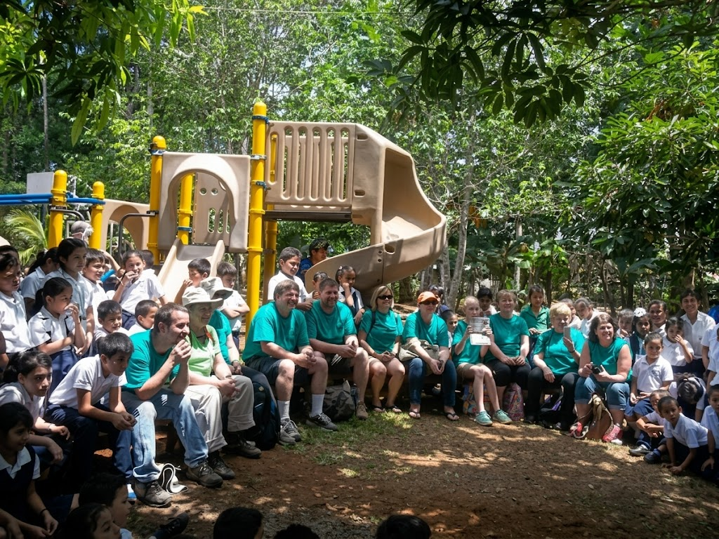 Un equipo misionero y estudiantes en el parque de juegos